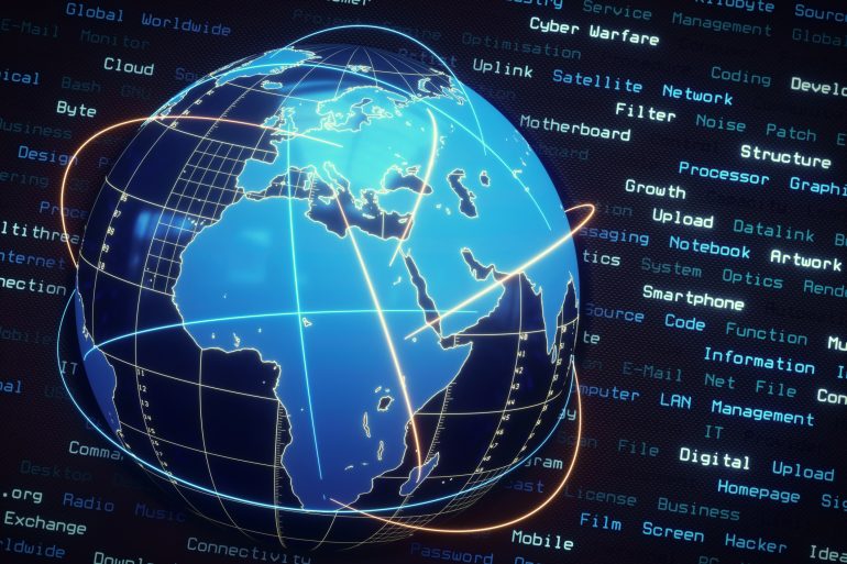 Um globo mundial digital azul mostrando a Europa, África e Ásia. O globo é cercado por linhas de comunicação rodopiantes e o plano de fundo da imagem apresenta linhas de texto com palavras-chave do setor de TI.
