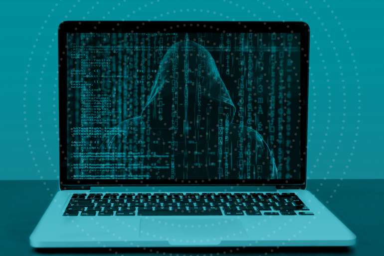 Imagem de ataque cibernético, na qual aparece um hacker na tela do computador e códigos.