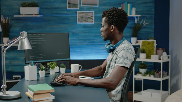 Imagem de um homem negro digitando no computador.